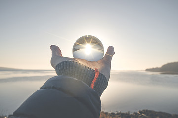 Image showing Hand holding a crystal ball in the winter sunrise