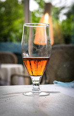 Image showing Half of a glass of beer on a table