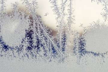 Image showing Sunrise behind a window with frost patterns