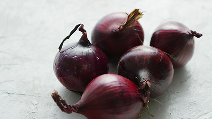 Image showing Red onion bulbs on white table