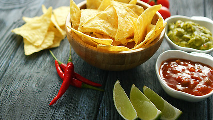 Image showing Delicious nachos and sauces on table