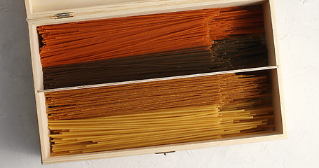 Image showing Multicolored spaghetti in wood box