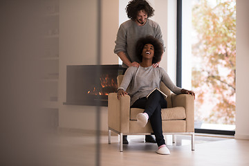 Image showing multiethnic couple hugging in front of fireplace