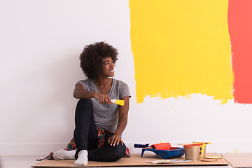 Image showing back female painter sitting on floor