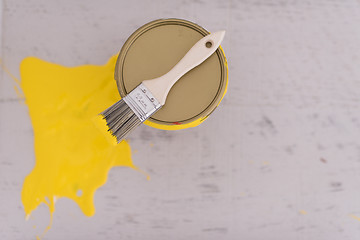 Image showing Yellow paint tin can with brush on top