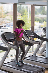 Image showing afro american woman running on a treadmill