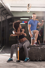 Image showing multiethnic couple after workout with hammer