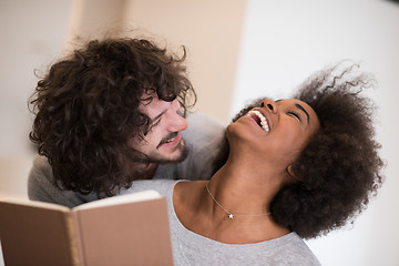 Image showing multiethnic couple hugging in front of fireplace