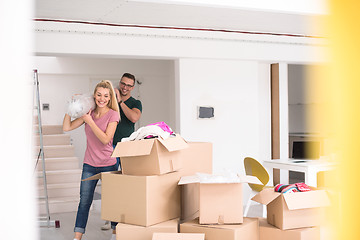 Image showing couple carrying a carpet moving in to new home