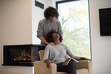 Image showing multiethnic couple hugging in front of fireplace