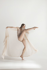 Image showing Young beautiful dancer in beige swimsuit dancing on gray background