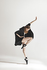 Image showing Young beautiful dancer in beige swimsuit dancing on gray background