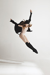 Image showing Young beautiful dancer in beige swimsuit dancing on gray background