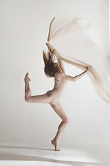 Image showing Young beautiful dancer in beige swimsuit dancing on gray background