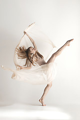 Image showing Young beautiful dancer in beige swimsuit dancing on gray background