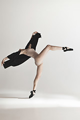 Image showing Young beautiful dancer in beige swimsuit dancing on gray background