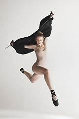 Image showing Young beautiful dancer in beige swimsuit dancing on gray background