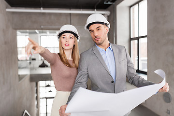 Image showing architects with blueprint and helmets at office