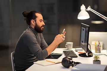 Image showing creative man with smartphone at night office