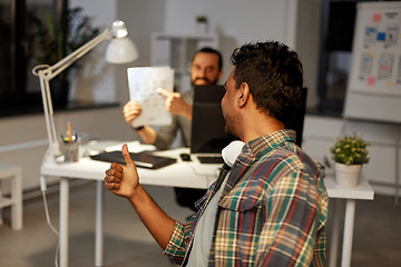 Image showing creative man showing papers to colleague at office