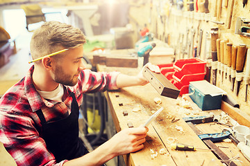 Image showing carpenter working with wood plank at workshop