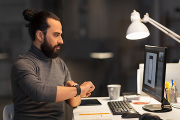 Image showing designer with smartwatch and computer at office