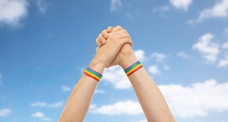 Image showing hands with gay pride wristbands in winning gesture