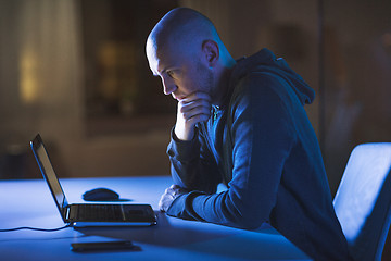 Image showing hacker with laptop computer in dark room