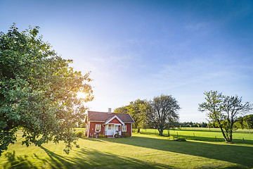 Image showing Small red house on a swedish countryside landscape