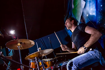 Image showing Drummer playing on drum set on stage.