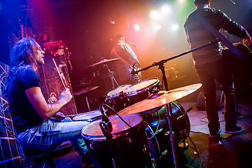 Image showing Drummer playing on drum set on stage.