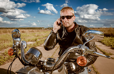 Image showing Biker talking on a smartphone.