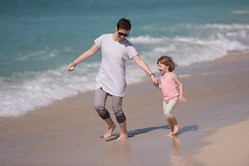 Image showing mother and daughter running on the beach