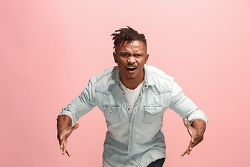 Image showing The young emotional angry afro man screaming on pink studio background