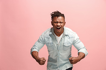 Image showing The young emotional angry afro man screaming on pink studio background