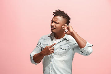 Image showing The Ear ache. The sad Faro-American man with headache or pain on a pink studio background.