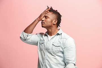 Image showing African American Man having headache. Isolated over pink background.