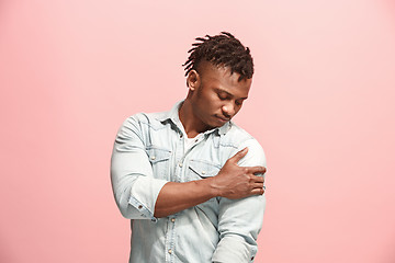 Image showing Young afro man overwhelmed with a pain in the shoulder .