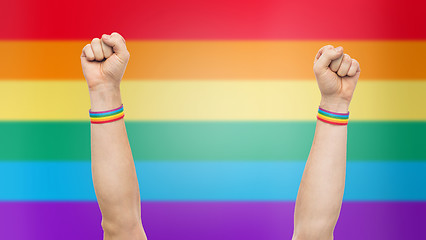Image showing hands with gay pride rainbow wristbands shows fist