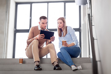 Image showing man and woman with tablet pc and coffee on stairs