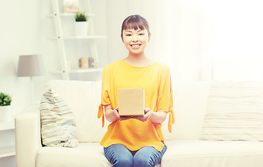 Image showing happy asian young woman with parcel box at home