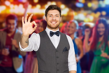 Image showing man in suit showing ok sign over night club party