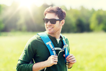 Image showing happy young man with backpack hiking outdoors