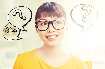 Image showing happy asian woman in glasses over question marks