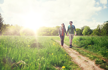 Image showing happy couple with backpacks hiking outdoors