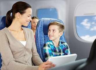 Image showing happy family with tablet pc sitting in plane