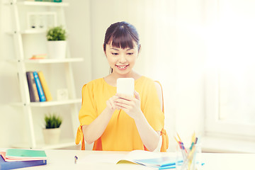 Image showing happy young woman student with smartphone at home