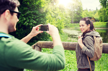 Image showing couple with backpacks taking picture by smartphone