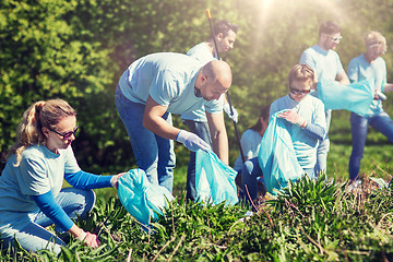 Image showing volunteers with garbage bags cleaning park area