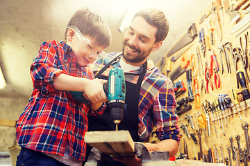 Image showing father and son with drill working at workshop